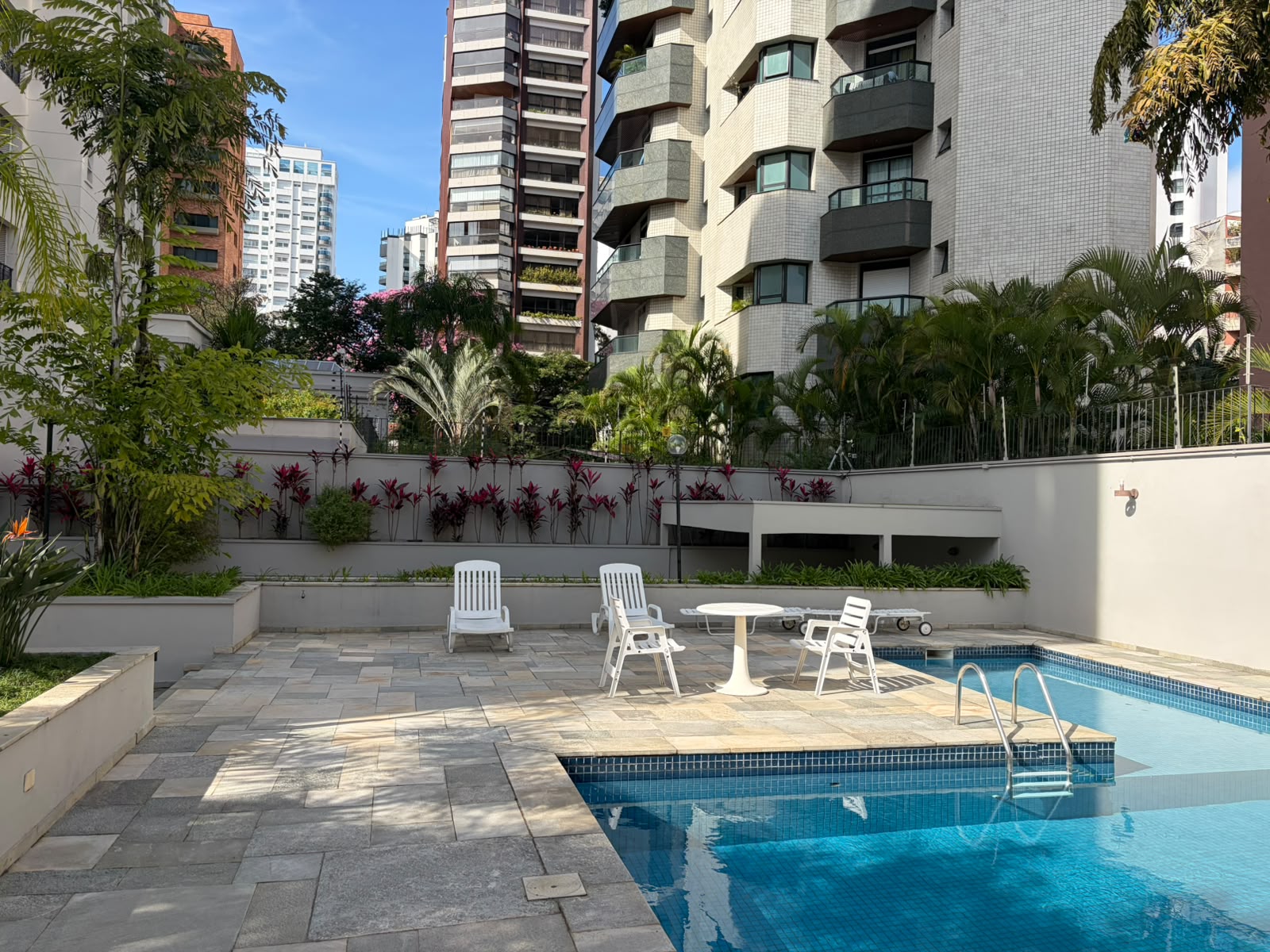 Piscina e área de descanso com jardim