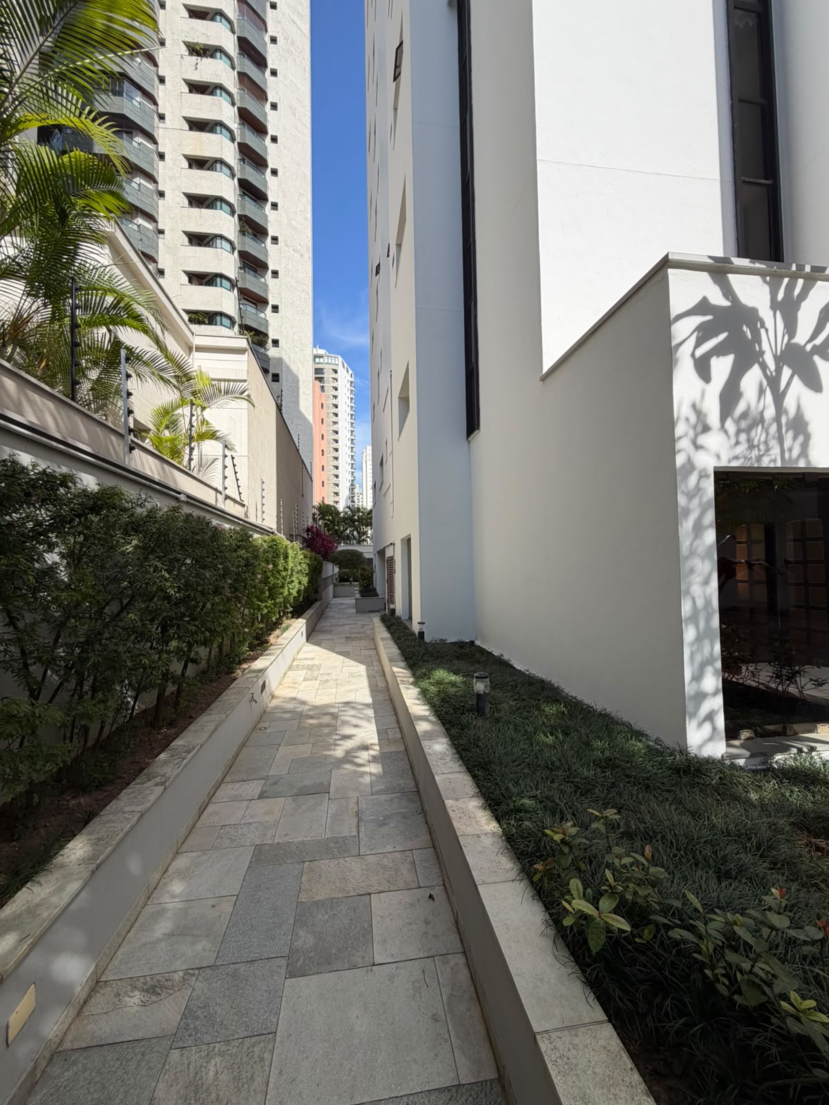 Passagem em pedra portuguesa entre o jardim